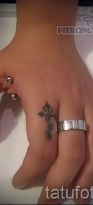 Фото заслуживающей внимания уже нанесенной на тело тату на пальце с крестом для выбора и создания своего рисунка – вариант