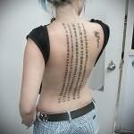 татуировка иероглифы столбиками на спине девушки