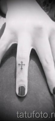 Фото интересной уже нанесенной на тело татуировки на пальце с крестом для выбора и создания своего эскиза – идея
