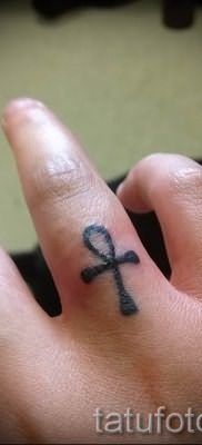 Фото достойной уже нанесенной на тело тату на пальце с крестом для выбора и создания своего рисунка – пример