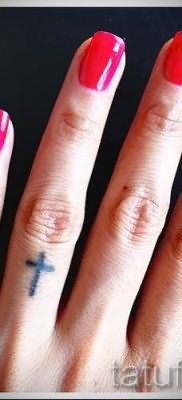 Фото крутой уже нанесенной на тело тату на пальце с крестом для выбора и создания своего рисунка – пример