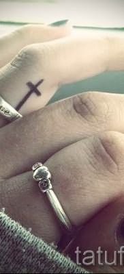 Фотография заслуживающей внимания уже нанесенной на тело татуировки на пальце с крестом для подбора и создания своего эскиза – пример