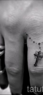 Фотография заслуживающей внимания уже нанесенной на тело тату на пальце с крестом для подбора и создания своего эскиза – пример