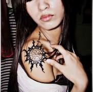 татуировка солнце черным цветом на плече у симпатичной азиатской девушки