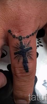 Фотография интересной уже нанесенной на тело татуировки на пальце с крестом для подбора и создания своего эскиза – идея