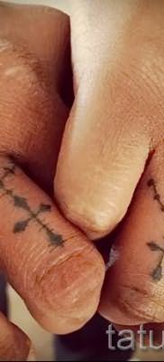 Фотография крутой уже нанесенной на тело тату на пальце с крестом для подбора и создания своего рисунка – вариант
