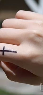 Фото заслуживающей внимания уже нанесенной на тело татуировки на пальце с крестом для подбора и создания своего эскиза – идея