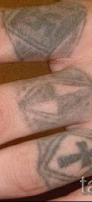Фотография заслуживающей внимания уже нанесенной на тело татуировки на пальце с крестом для подбора и отрисовывания своего эскиза – вариант