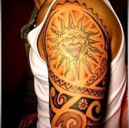 татуировка солнце показывает язык – маори стиль на плече для мужчины
