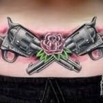 татуировка дле девушки с пистолетами и цветами на пояснице